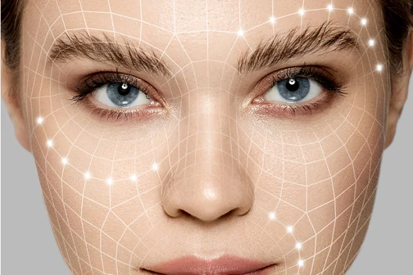 A woman with blue eyes and clear skin is overlaid with a digital grid pattern and glowing points, suggesting a focus on facial features or skin analysis.